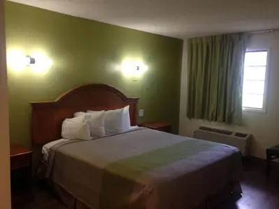 a hotel room with a bed and a window at Red Carpet Inn - New Brunswick in New Brunswick