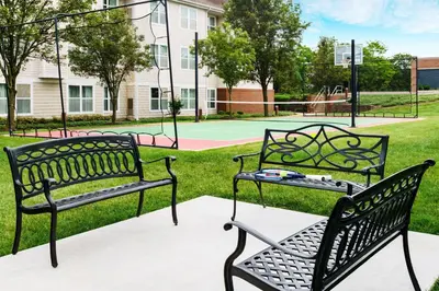 three benches in a park with a tennis court at Residence Inn by Marriott Philadelphia Montgomeryville in North Wales