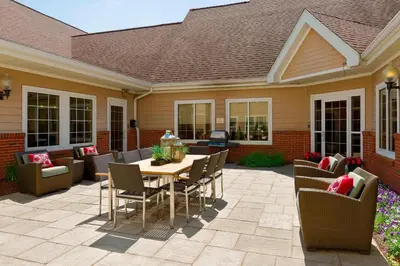 a patio with a wooden table and chairs at Residence Inn by Marriott Philadelphia Montgomeryville in North Wales