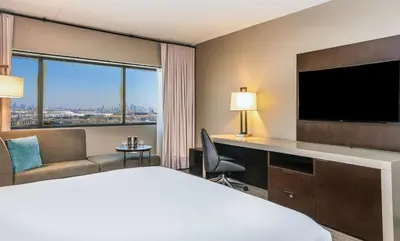 a hotel room with a bed and a flat screen tv at DoubleTree by Hilton Hotel Newark Airport in Newark