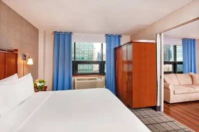a bedroom with a bed and a couch and a window at Four Points by Sheraton Midtown - Times Square in New York