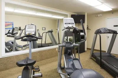 a gym with cardio equipment in front of a mirror at Days Inn by Wyndham Harrisburg North in Harrisburg