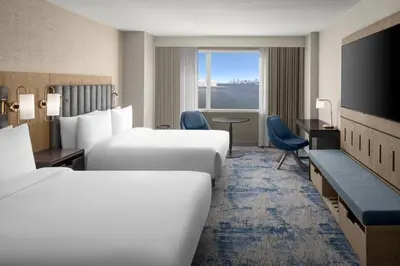 a hotel room with two beds and a television at Hyatt Regency Jersey City on the Hudson in Jersey City