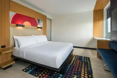 a large white bed in a room with a rug at Aloft Mount Laurel in Mount Laurel