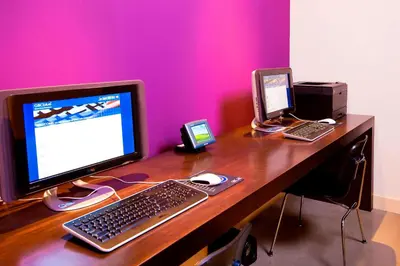 a desk with a computer monitor and a keyboard and mouse at Aloft Mount Laurel in Mount Laurel