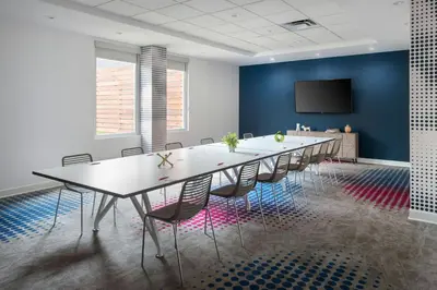 a conference room with a long table and chairs at Aloft Mount Laurel in Mount Laurel