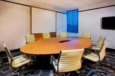 a conference room with a wooden table and chairs at Aloft Mount Laurel in Mount Laurel