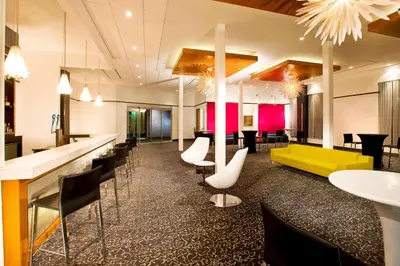 a hotel lobby with a yellow couch and chairs at Aloft Mount Laurel in Mount Laurel
