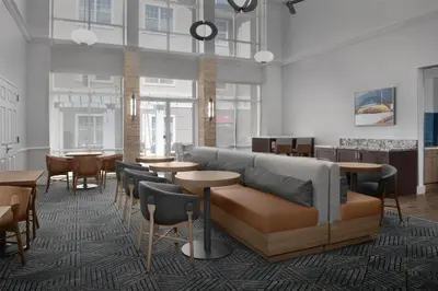 a lobby with a couch and tables and chairs at Homewood Suites by Hilton Newark-Cranford in Cranford