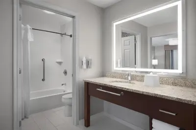 a bathroom with a sink and a toilet and a mirror at Homewood Suites by Hilton Newark-Cranford in Cranford