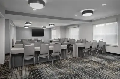 a conference room with tables and chairs and a screen at Homewood Suites by Hilton Newark-Cranford in Cranford