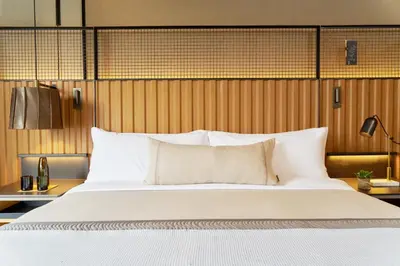 a bedroom with a large bed and wooden wall at 1 Hotel Brooklyn Bridge in Brooklyn