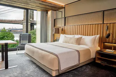 a bedroom with a large bed and a large window at 1 Hotel Brooklyn Bridge in Brooklyn