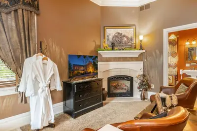 a living room with a fireplace and a chair at The Londonderry Inn in Hershey