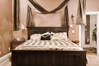 a bedroom with a large bed with a wooden headboard at The Londonderry Inn in Hershey