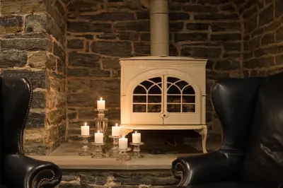 a table with candles and chairs in a brick wall at The Londonderry Inn in Hershey