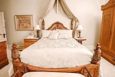 a bedroom with a large bed with a wooden headboard at The Londonderry Inn in Hershey