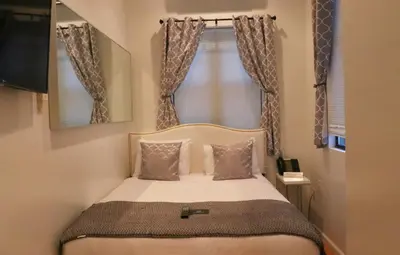a small bedroom with a bed in front of a window at Chelsea Inn in New York