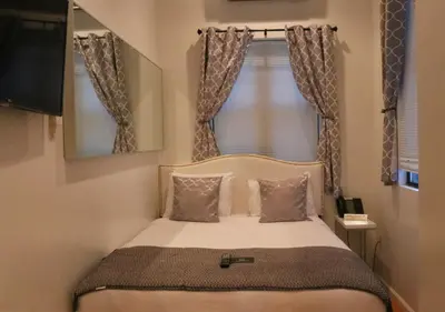 a small bedroom with a bed with a window at Chelsea Inn in New York