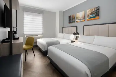a hotel room with two beds and a chair at Citadines Connect Fifth Avenue New York in New York