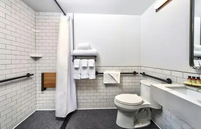 a white bathroom with a toilet and a sink at Citadines Connect Fifth Avenue New York in New York