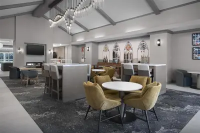 a lobby with a table and chairs and a bar at Homewood Suites by Hilton Princeton in Princeton