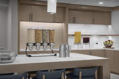 a kitchen with a table and some blue chairs at Homewood Suites by Hilton Princeton in Princeton