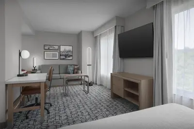 a hotel room with a bed and a desk with a desk at Homewood Suites by Hilton Princeton in Princeton