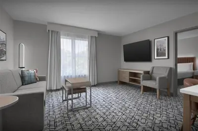 a hotel room with a couch and a tv at Homewood Suites by Hilton Princeton in Princeton