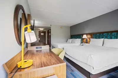 a hotel room with two beds and a desk at Hampton Inn Ridgefield Park in Ridgefield Park
