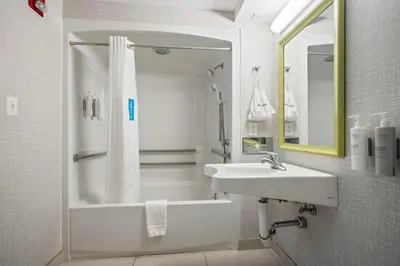 a white bathroom with a shower and a sink at Hampton Inn Ridgefield Park in Ridgefield Park