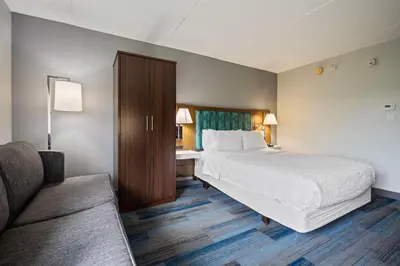 a hotel room with a bed and a couch at Hampton Inn Ridgefield Park in Ridgefield Park