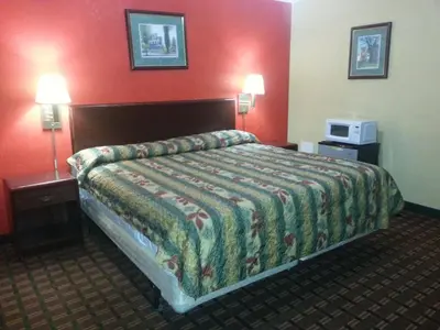 a hotel room with a bed and two lamps at Mount Laurel Motel in Hazleton