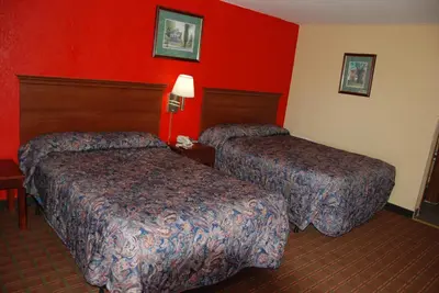 two beds in a hotel room with red walls at Mount Laurel Motel in Hazleton