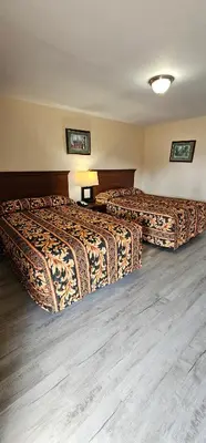 two beds in a hotel room with wooden floors at Mount Laurel Motel in Hazleton