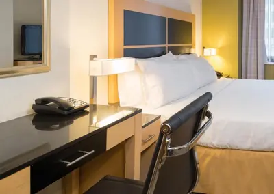 a hotel room with a bed and a desk with a phone at Holiday Inn Express - Wall Street by IHG in New York