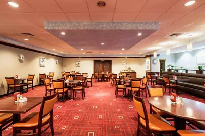 a dining room with wooden tables and chairs at Crowne Plaza Newark Airport by IHG in Elizabeth