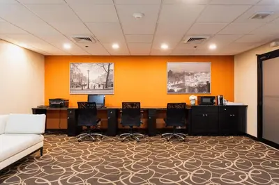 a office with a desk and chairs and a couch at Crowne Plaza Newark Airport by IHG in Elizabeth