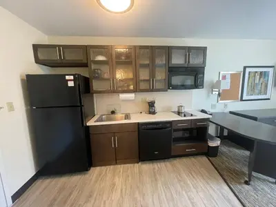 a kitchen with a black refrigerator and a sink at Candlewood Suites Secaucus by IHG in Secaucus