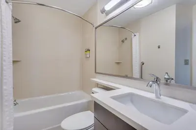 a bathroom with a sink and a toilet and a mirror at Candlewood Suites Secaucus by IHG in Secaucus
