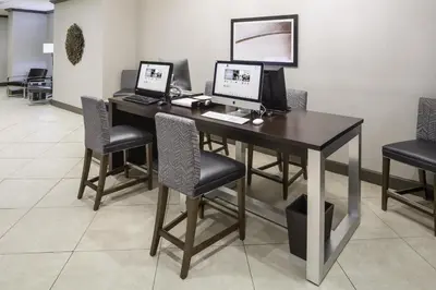 a desk with two computers on it in a room at DoubleTree by Hilton Hotel Wilmington in Wilmington