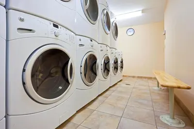 a row of white washing machines in a laundry room at Candlewood Suites NYC -Times Square by IHG in New York