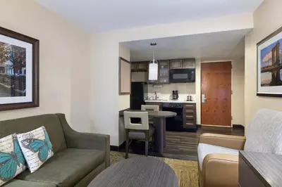 a living room with a couch and a kitchen at Candlewood Suites NYC -Times Square by IHG in New York