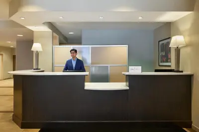 a man sitting at a counter in a hotel lobby at Candlewood Suites NYC -Times Square by IHG in New York
