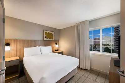 a hotel room with a bed and a window at Sonesta Simply Suites Jersey City in Jersey City