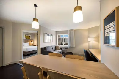 a room with a dining table and a living room at Sonesta Simply Suites Jersey City in Jersey City