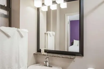 a bathroom with a mirror and a sink at La Quinta by Wyndham New York City Central Park in New York