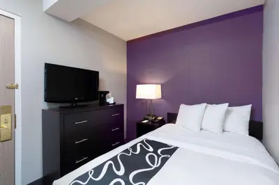 a bedroom with a bed and a flat screen tv at La Quinta by Wyndham New York City Central Park in New York