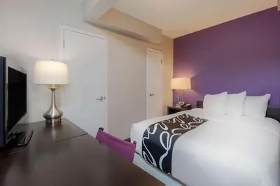 a bedroom with a white bed and a purple wall at La Quinta by Wyndham New York City Central Park in New York