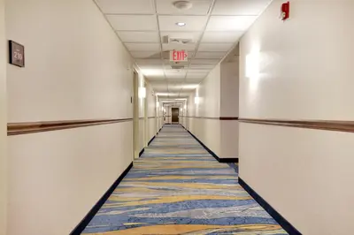 an empty hallway in an office building with a carpet at Horizon Inn in Avenel